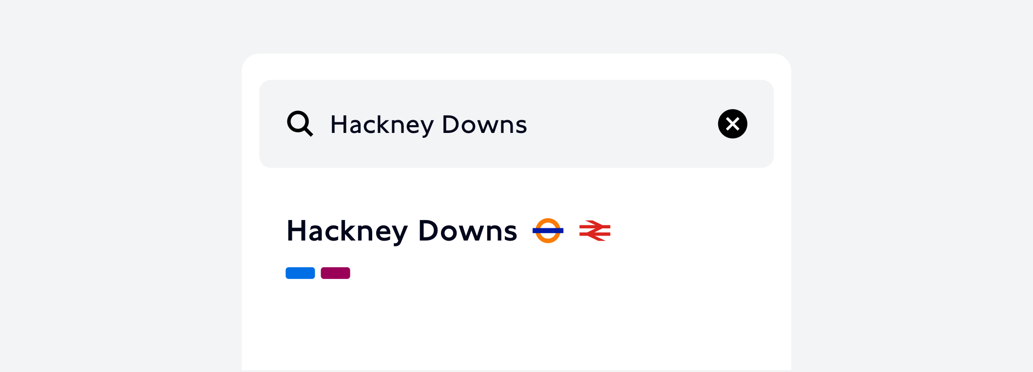 An example of UI design for a search result for Hackney Downs station. The result is displayed underneath a search field containing an icon of a magnifying glass and the word “Hackney Downs”. The search result includes the name of the station, the London Overground icon, the National Rail icon, and two round cornered rectangles in blue and purple, signifying the Mildmay and the Weaver lines.