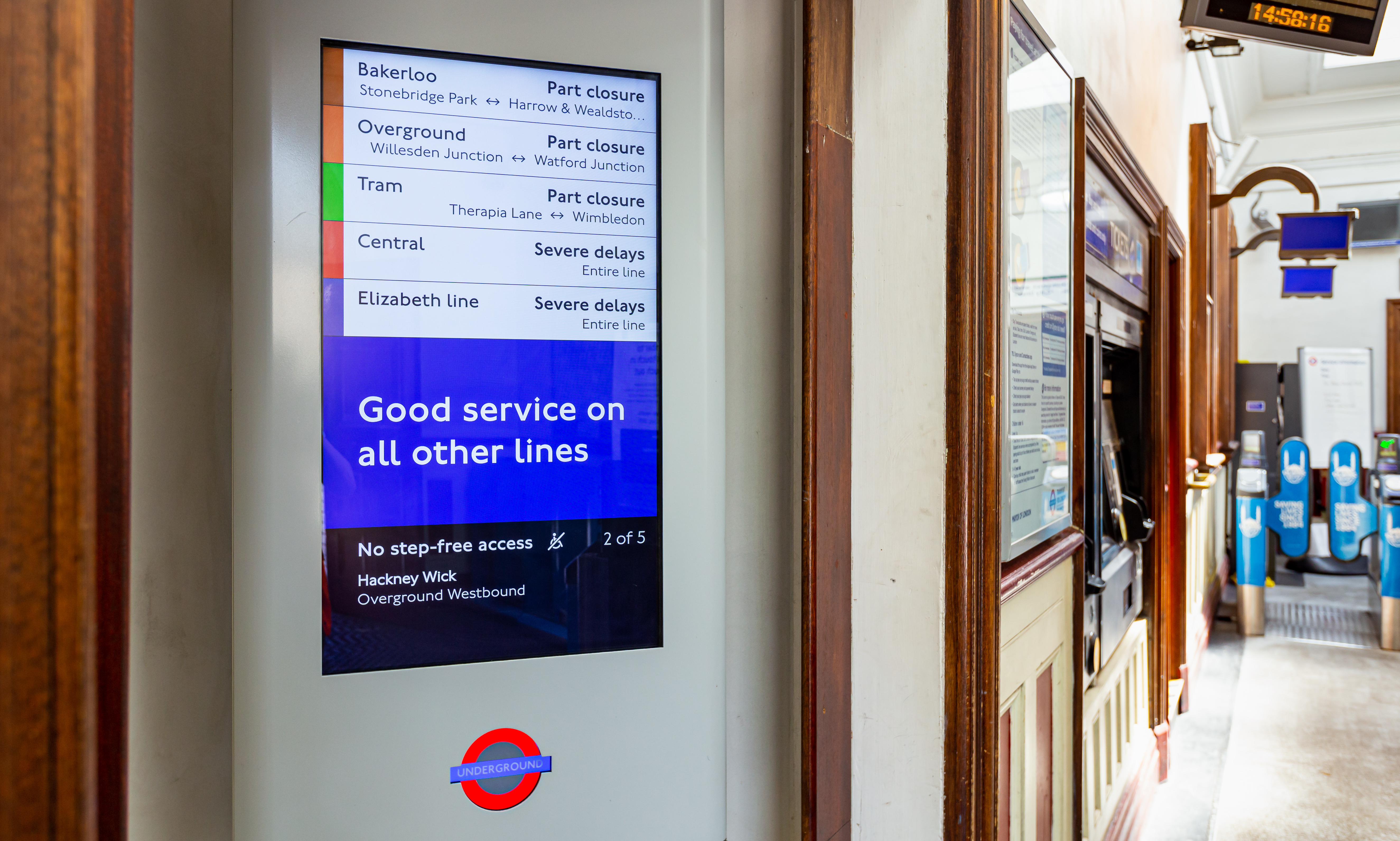 Close-up photograph of a screen placed at the entrance of a station. The screen is showing service status across the network, showing lines that are disrupted as well as stations where step-free access is disrupted.